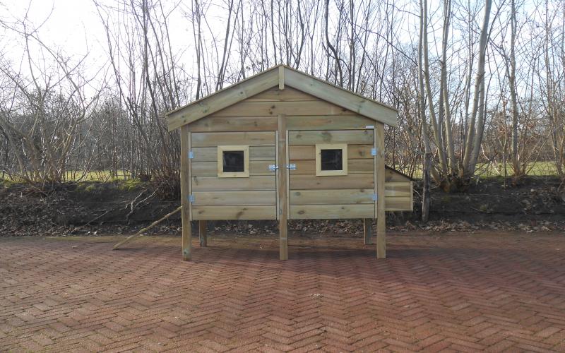 Houten nachthok met raampjes op voorzijde.